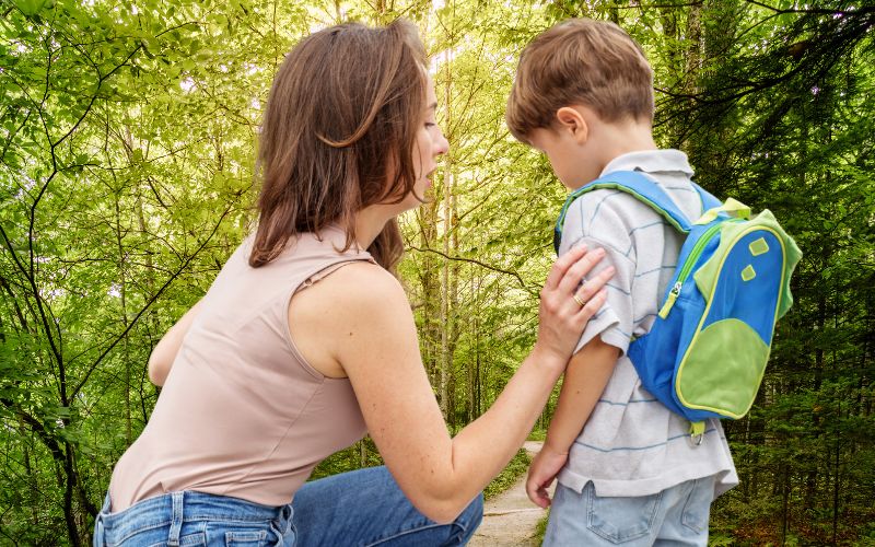 Mutter verabschiedet sich von Kind im Waldkindergarten